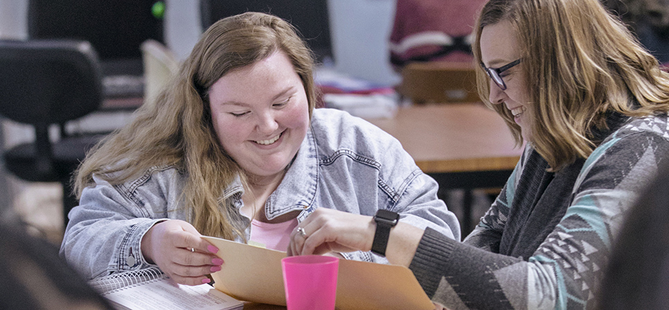 a student and tutor looking at a paper together in the writing center