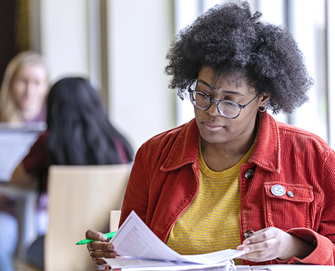 a student highlighting her notes