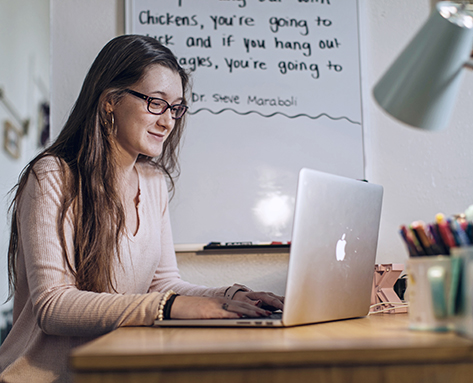 a student working on her laptop in her dorm room