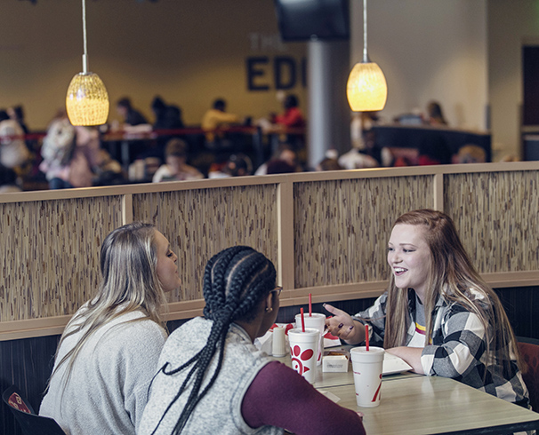 three students eating chik-fil-a in the student center