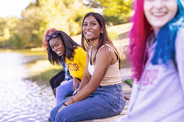 a group of students from different ethnic groups sitting beside winthrop lake