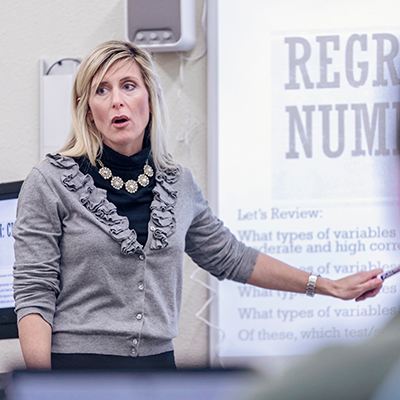 Woman giving a presentation and pointing at a projected presentation