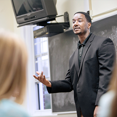 Man talking to a room in a class setting