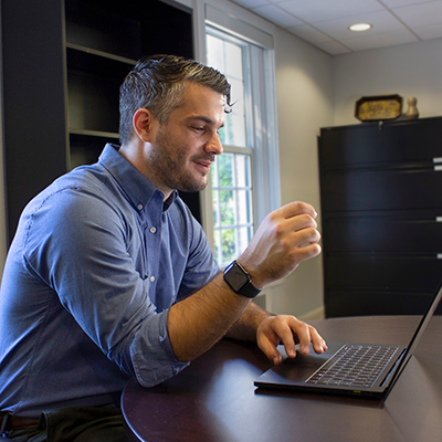 Man sitting at a desk working on a laptop