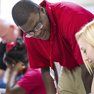 African American male teacher talking with students