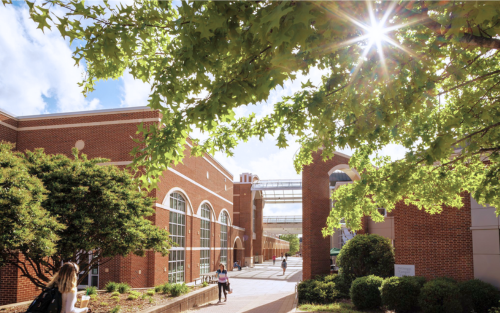 walkway between the West Center and DiGiorgio Student Center framed by trees and sunlight