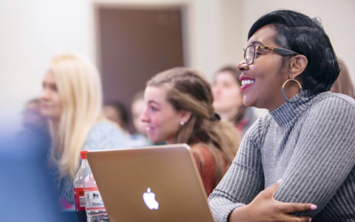 woman sitting in a classroom with a laptop