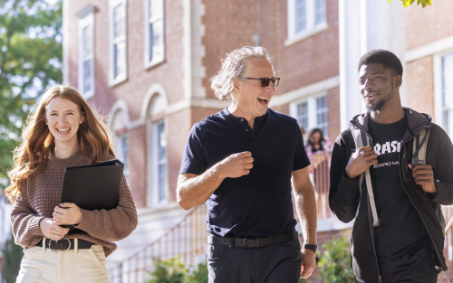 three people walking on campus laughing