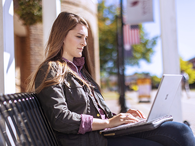 a student using a laptop outside
