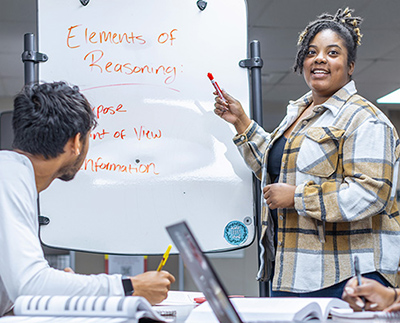 a student leading a discussion at a whiteboard