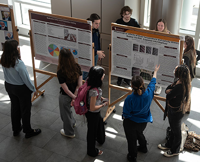 looking down at students giving poster presentations at an undergraduate research
                           event