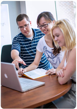 three adults at laptop