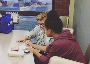 A student works on her paper with a tutor.